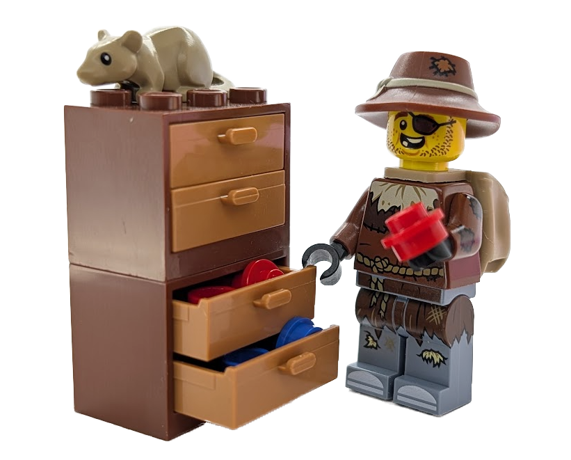Rusty Dusty holding a red brick beside drawers filled with colorful parts while his rat sits on top